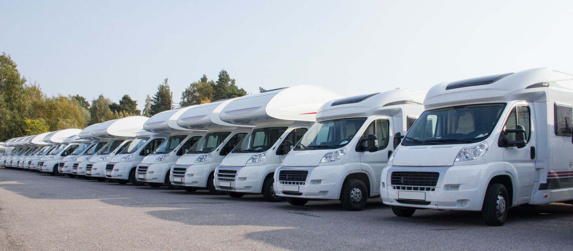 Viele weiße Wohnmobile stehen auf einem Parkplatz zur Vermietung bereit. Angebot vom Reifendienst Böhme in Vetschau.