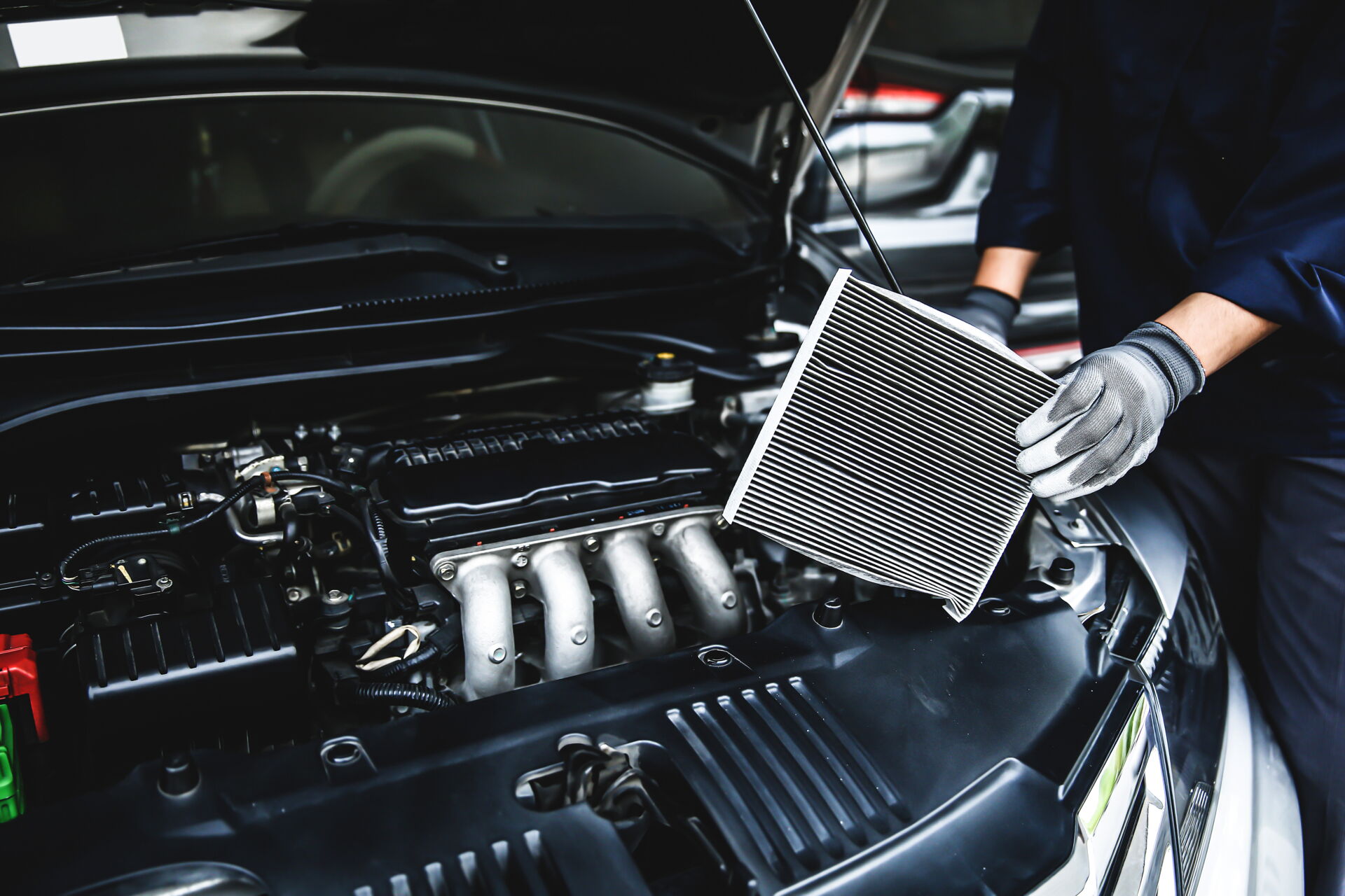 Klimaanlagen-Service in Vetschau | Reifendienst Böhme Ein Mechaniker wechselt den Innenraumfilter eines Autos. Reifendienst Böhme in Vetschau bietet Klimaanlagen-Service an.
